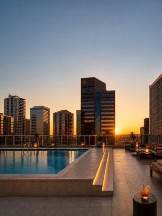 A serene rooftop pool at sunset, framed by modern city skyscrapers, creates a tranquil atmosphere perfect for relaxation.