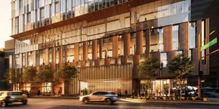 A modern building showcases sleek glass and wooden elements, surrounded by greenery. Street activity and vehicles complement the urban scene.