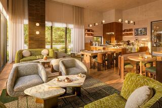 A cozy, modern café featuring stylish seating, wood accents, and large windows that invite natural light, creating a warm, inviting atmosphere.