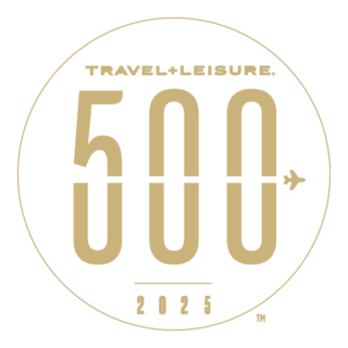 A circular logo featuring "TRAVEL+LEISURE." at the top, "500" in bold, and "2025" at the bottom, with an airplane icon beside the number.