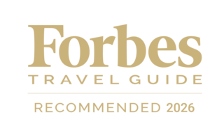 Logo featuring "Forbes Travel Guide" in gold, with "Recommended 2026" emphasized, indicating a prestigious endorsement for travel services.